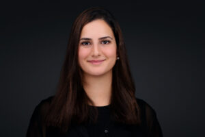 Smiling woman with long straight dark brown hair wearing a black shirt